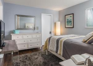 a bedroom with a bed and a mirror and a dresser at Captain's Quarters Riverfront #3 in Nashville