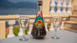 une bouteille et deux verres à vin assis sur une table dans l'établissement ARI Apartments, à Krasići