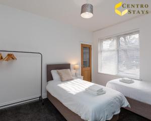 北安普敦的住宿－Relocation Families Contractors FREE PARKING，一间卧室设有两张床和窗户。