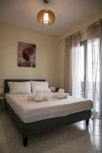 Una cama grande en un dormitorio con una ventana grande. en Azur Deluxe apt., en Pefkohori 19 fotos más