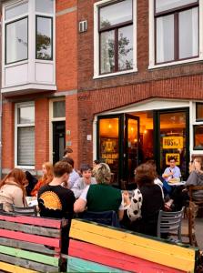 un groupe de personnes assis à l'extérieur d'un restaurant dans l'établissement Hostel The Golden Stork, à La Haye