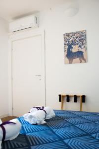 OLIVE TREE private room in home في ميرات: غرفة نوم بسرير وبطانية زرقاء وبيضاء