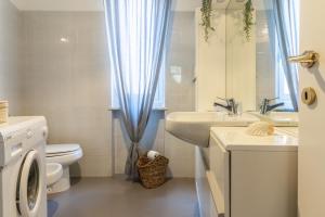 a bathroom with a sink toilet and a blue curtain at La Casa di Madi in Riomaggiore +35 photos