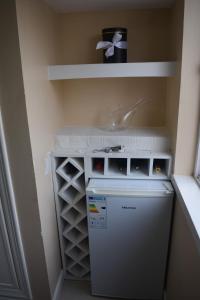 a laundry room with a small refrigerator and a sink at Cozy Studio in Luanda