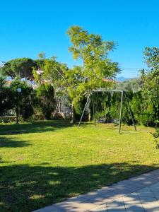 un parc avec une balançoire installée dans un champ dans l'établissement SISSOU VILLAGe PLACe, à Kalamata