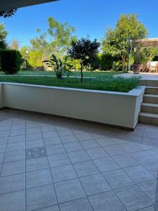 a white wall sitting on a tiled floor next to a park at SISSOU VILLAGe PLACe in Kalamata