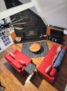 sala de estar con 2 sofás rojos y chimenea en **Special Rate** Peaceful Cabin with Gameroom near Downtown Gatlinburg en Gatlinburg