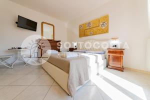 Schlafzimmer mit einem Bett und einem Tisch in der Unterkunft Villino Montale in Porto Cesareo
