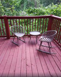 2 sillas y una mesa en una terraza de madera en **Special Rate** Peaceful Cabin with Gameroom near Downtown Gatlinburg, en Gatlinburg