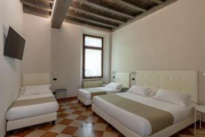 a bedroom with two beds and a flat screen tv at Ca' Tazzoli in Mantova