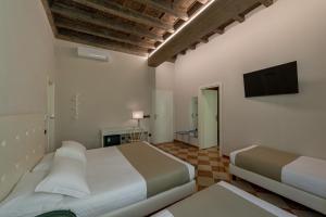a bedroom with two beds and a flat screen tv at Ca' Tazzoli in Mantova
