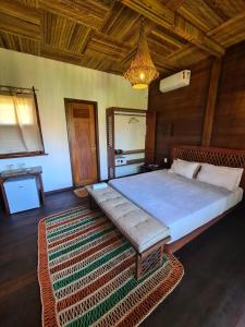 ein Schlafzimmer mit einem großen Bett mit einem Teppich in der Unterkunft Atins Charme Chalés in Atins