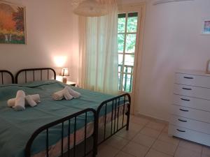 a bedroom with a green bed and a window at Philly's sea side apartment in Agios Ioannis Pelio