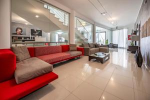 a living room with a red couch and a table at Villa Floyd Charming Rooms B&B in Pachino