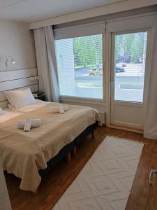 a bedroom with a large bed and a large window at Asuntos-2 in Lahti