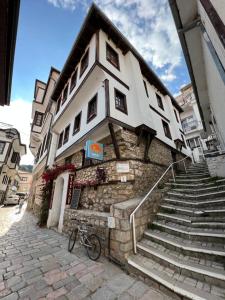 a building with stairs and a bike parked in front of it at Patche Residence - A Wine Cellar Hideaway in the Historic Home of Revolutionary Metodi Patche in Ohrid