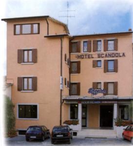 a building with two cars parked in front of it at Hotel Scandola in Bosco Chiesanuova