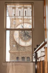 a window with a clock on a brick building at Luxury penthouse apartment in Baltimore