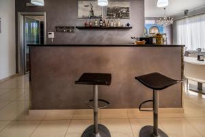 a bar with two stools in a kitchen at Villa Floyd Charming Rooms B&B in Pachino