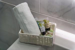 a basket on the side of a bath tub with towels at Luxury Apartment near Central London in London