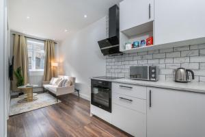 a kitchen with white appliances and a living room at Luxury Apartment near Central London in London
