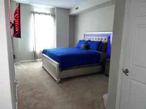 a bedroom with a bed with blue sheets and a window at Luxury penthouse apartment in Baltimore