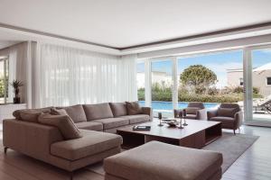 a living room with a couch and a table at Lusso Mare Istria Luxury Beach villa in Savudrija