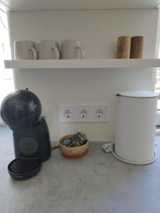 リエパーヤにあるCourtyard Condo Twinのボウルとテーブルが置かれた棚のある部屋