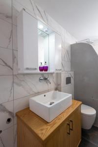 a bathroom with a white sink and a toilet at Alex Luxury Downtown House in Naxos Chora