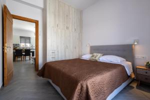 a bedroom with a large bed and a dining room at Alex Luxury Downtown House in Naxos Chora