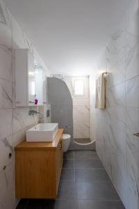 La salle de bains blanche est pourvue d'un lavabo et de toilettes. dans l'établissement Alex Luxury Downtown House, à Naxos Chora