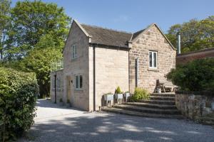 an old brick building with stairs in front of it at Luxurious Barn Conversion in Oakamoor