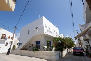 un bâtiment blanc sur le côté d'une rue dans l'établissement Alex Luxury Downtown House, à Naxos Chora