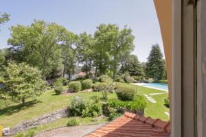 a view of a garden from a window at Morgado - River Suites and Houses by PCH in Padrões +78 photos