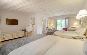 a bedroom with two beds and a flat screen tv at Hamilton Village Inn in North Kingstown