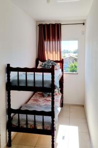 a bedroom with two bunk beds and a window at Apartamento Anna Carolina in Florianópolis