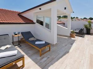 a patio with a couch and a chair on a house at Apartments Bubalo in Hvar