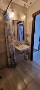 y baño con lavabo, espejo y cortina de ducha. en VApartments, en Kiev