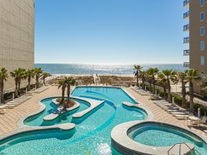 a large swimming pool next to a beach with palm trees at Crystal Tower 1509 by ALBVR - Luxurious 15th Floor Condo with Breathtaking Views in Gulf Shores