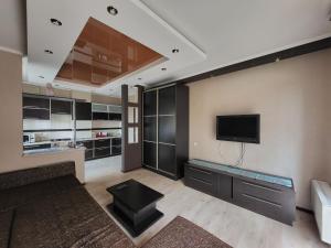 ein Wohnzimmer mit einem Flachbildfernseher an der Wand in der Unterkunft 1 кімнатна квартира-студія в новобудові in Czernowitz + 14 Fotos