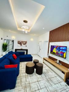 a living room with a blue couch and a tv at Luxurious1 bedroom apart in VI in Lagos