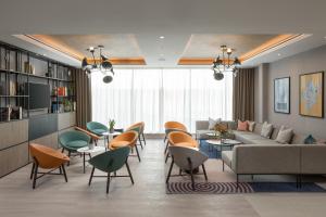 a living room with a couch and tables and chairs at Residence Inn by Marriott Manchester Piccadilly in Manchester
