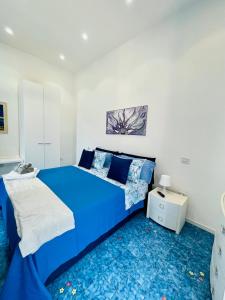 ein blaues Bett in einem weißen Zimmer mit blauem Teppich in der Unterkunft Il Sogno in Erchie