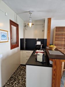 a kitchen with a black counter and a sink at Apartamentos Wundermar in Torredembarra