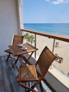 a table and chairs on a balcony with the beach at Apartamentos Wundermar in Torredembarra