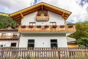 a house with a balcony with flowers on it at Casa Facco in Bocenago