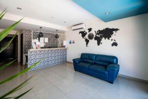 a living room with a blue couch and a world map on the wall at Hotel Ambra in Playa del Carmen