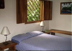 1 dormitorio con cama y ventana en Piscina Natural on the Sea en Cahuita