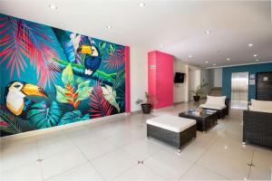 a lobby with a large mural of birds and plants at Hotel Ambra in Playa del Carmen