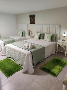 a bedroom with two beds with green rugs at HOUSEMARIA in Nazaré